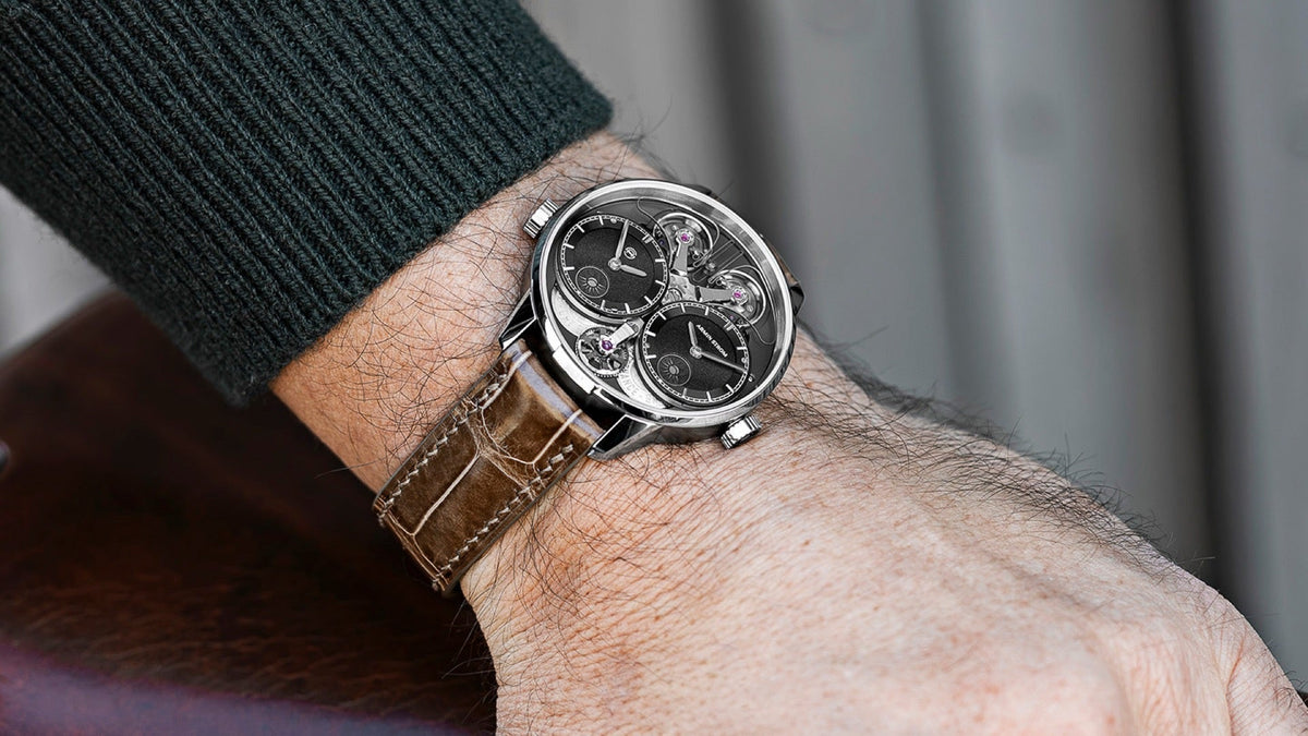 Armin Strom Dual Time GMT Resonance Manufacture Edition Black worn on the wrist, resting on a leather bicycle saddle