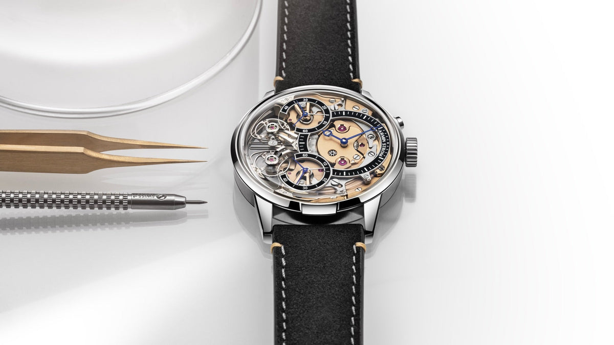 Armin Strom Mirrored Force Resonance Zeitgeist 1665 3N beside watchmaker’s tweezers
