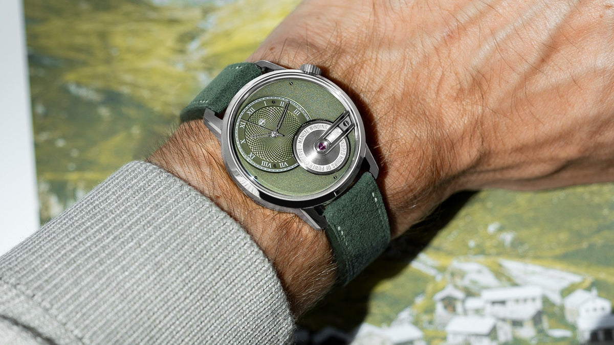 Armin Strom Tribute 1 Green worn on the wrist against a green mountain backdrop