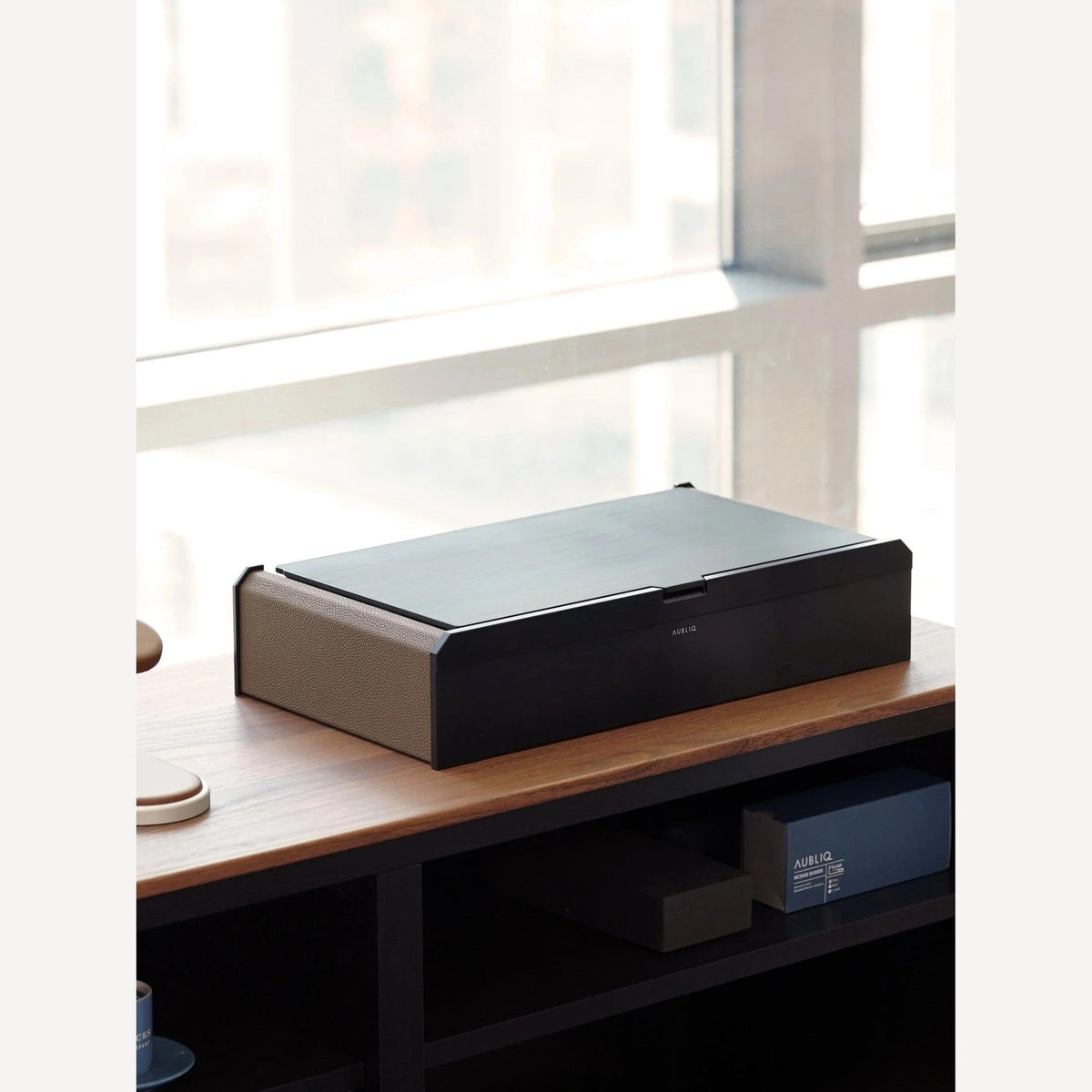 Aubliq Attention Watch Storage Box in Ebony Black on a cabinet by a window