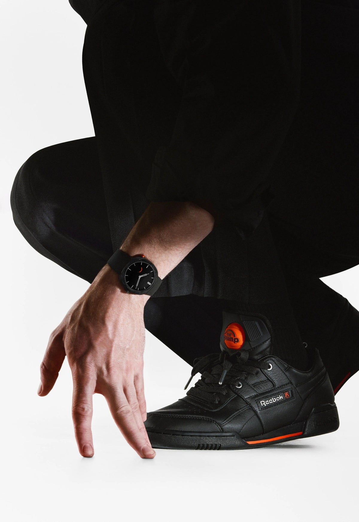 H. Moser & Cie. x Reebok Streamliner Pump Black worn on the wrist, next to the matching black Pump sneaker