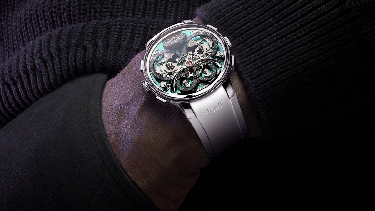 MB&F LM Sequential Flyback EVO worn on the wrist under a dark sweater sleeve, aquamarine dial plate visible