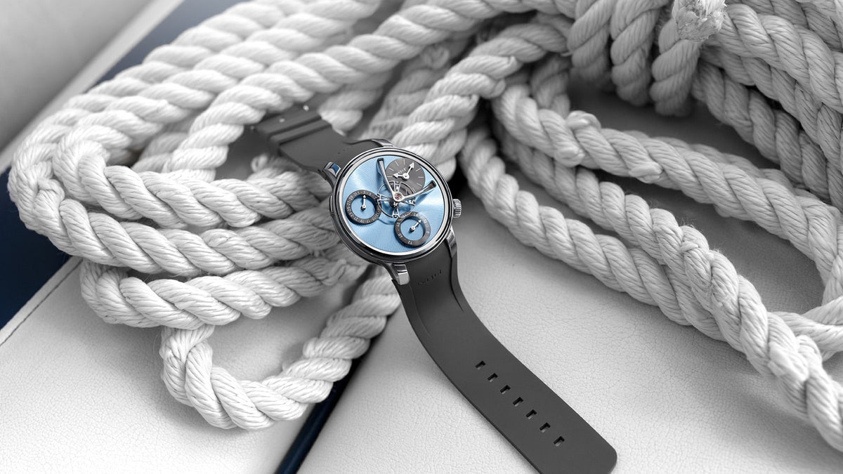 MB&F Legacy Machine Split Escapement EVO with icy blue base plate and grey rubber strap, lying on white rope