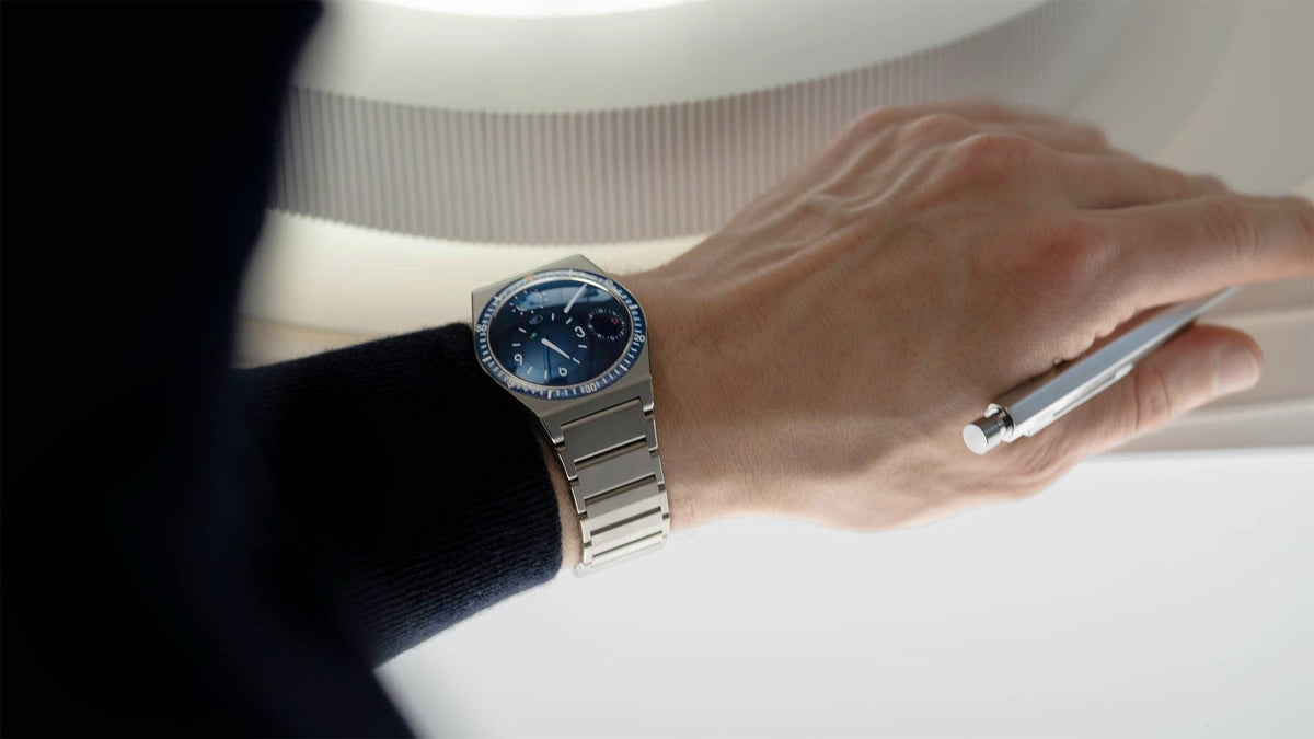 Ressence TYPE 7 Night Blue worn on the wrist, writing at a desk