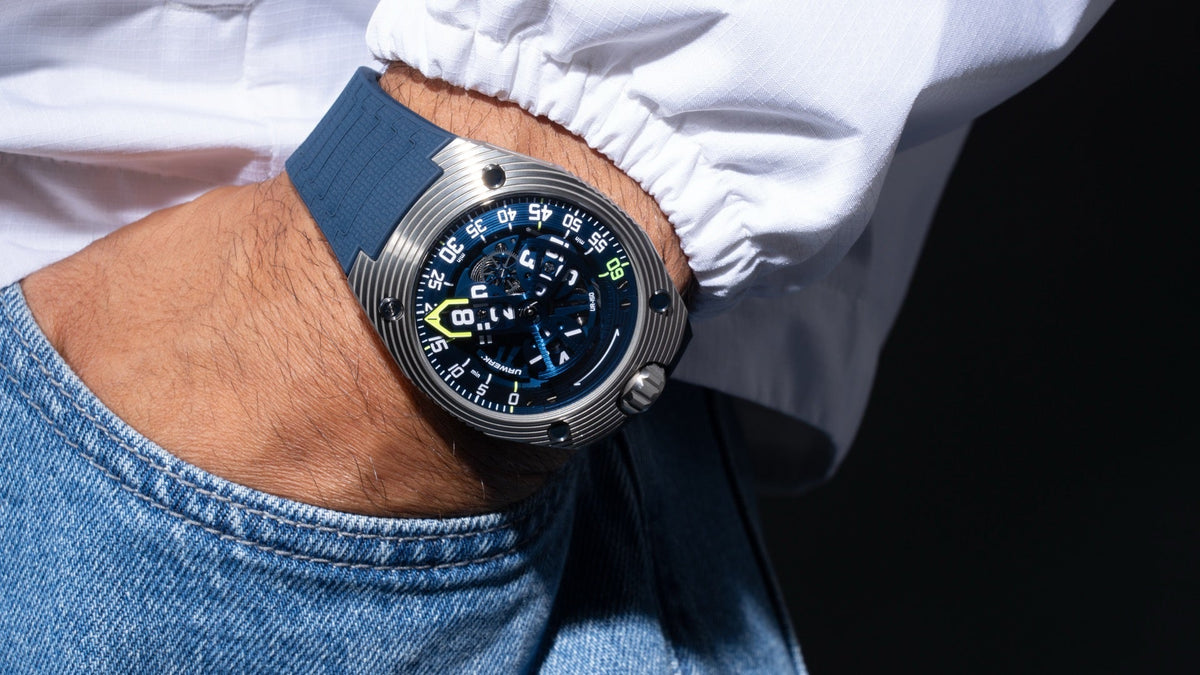 URWERK UR-150 Blue Scorpion worn on the wrist, hand in a jeans pocket, white shirt sleeve
